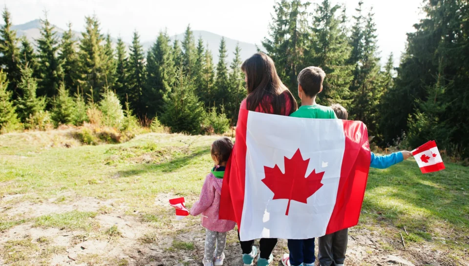happy-canada-day-family-mother-with-three-kids-hold-large-canadian-flag-celebration-mountains
